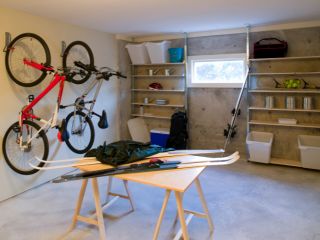 Custom Garage Storage and Organization – Cedar Hill, TX Organized garage in Cedar Hill, TX, featuring wall-mounted bike racks, open shelving with bins and sports gear, and a central worktable for projects.