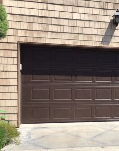 Newly installed brown sectional garage door with raised panels, enhancing the curb appeal of a Dallas residence.