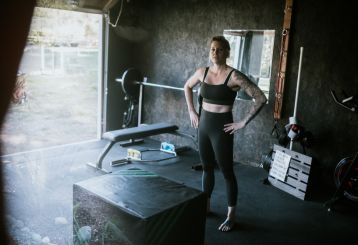 A modern garage gym in Cedar Hill, TX, featuring a workout bench, plyometric box, and organized fitness equipment with natural light streaming in from an open garage door.