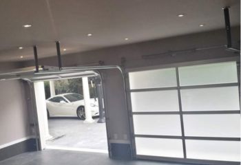 Open electric overhead garage door revealing luxury car and modern home exterior in Arlington