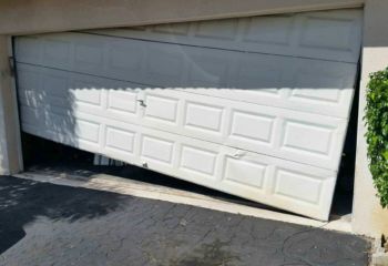 Garage door stuck off track and slanted at Cedar Hill home driveway