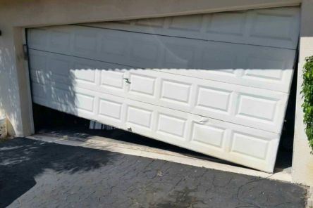 Garage door stuck off track and slanted at Cedar Hill home driveway