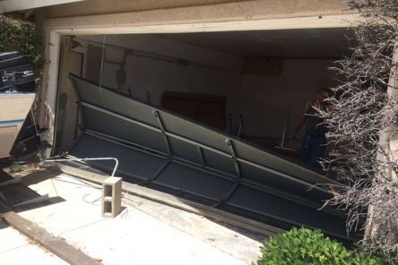 Technician inspecting damage before new overhead garage door installation in Cedar Hill